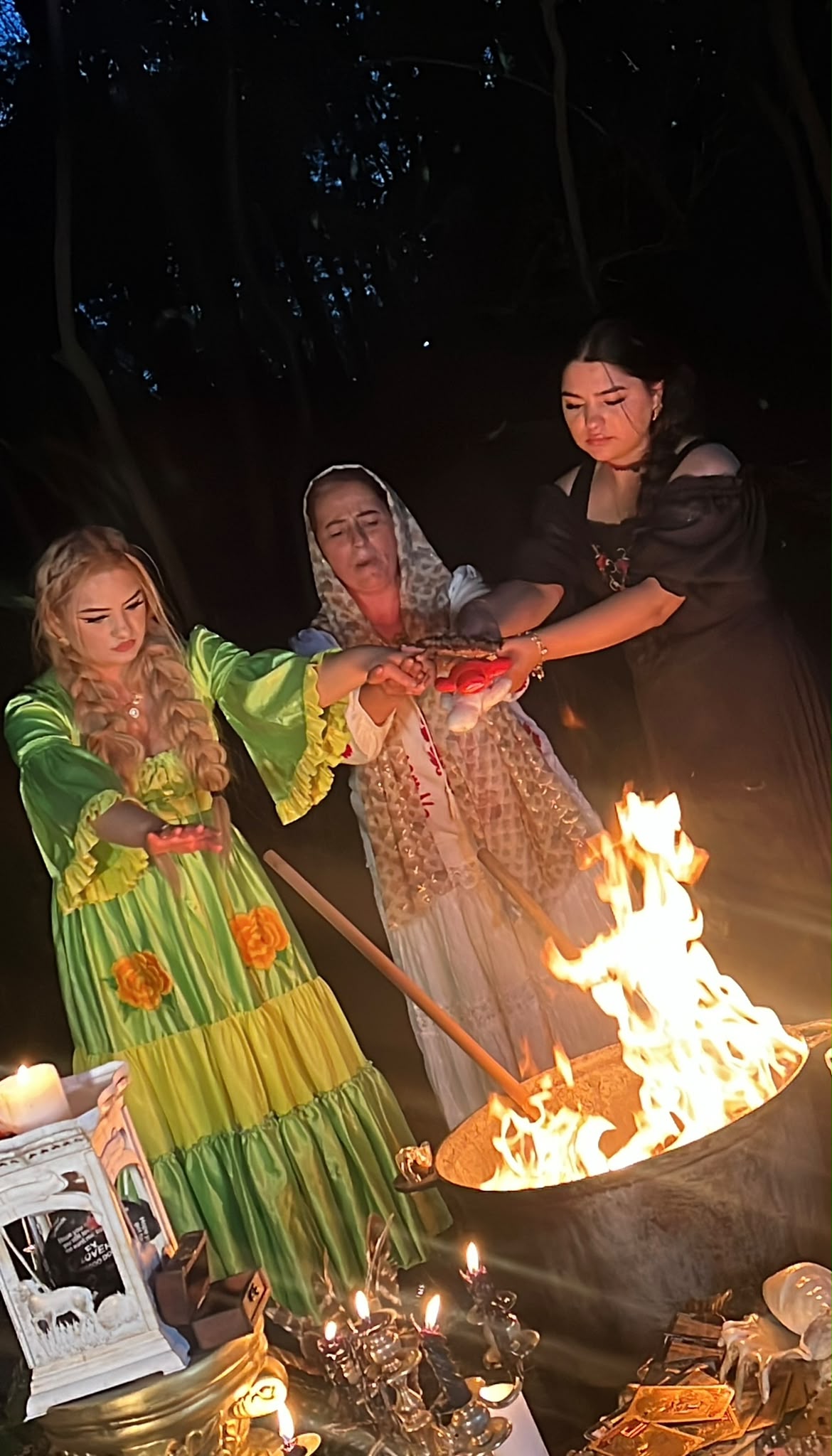 Francesca împreună cu alte două femei, cu mâinile unite deasupra focului, într-un ritual de noapte